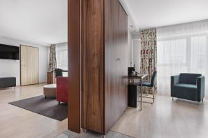 Habitación con escritorio, silla y habitación en Hotel Moderno Poznań en Poznan