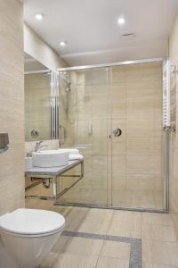 a bathroom with a shower and a toilet and a sink at Hotel Moderno Poznań in Poznań