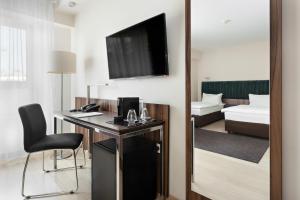 Televízia a/alebo spoločenská miestnosť v ubytovaní Hotel Moderno Poznań