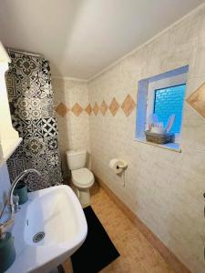 a bathroom with a sink and a toilet and a window at Casa de Pera in Mytilini