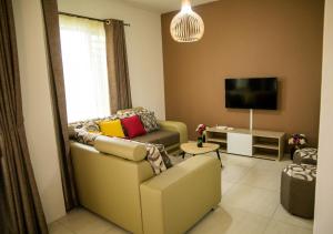a living room with a couch and a tv at New Luxury 2 Bedroom Apartment with Pool - close to Flic-en-Flac Beach in Flic-en-Flac