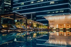 a hotel pool with chairs and a building at The Fullerton Bay Hotel Singapore in Singapore
