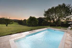 - une grande piscine dans une cour avec un terrain dans l'établissement Roulotte Paradis: insolite, SPA privatif, piscine, 