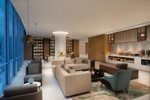a living room with couches and chairs and a kitchen at Somerset Gaoxin Chengdu in Chengdu