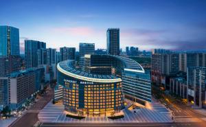 un grand bâtiment avec des fenêtres jaunes dans une ville dans l'établissement Somerset Gaoxin Chengdu, à Chengdu