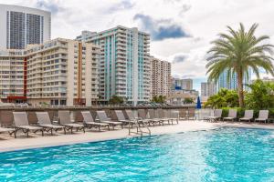 a swimming pool with lounge chairs and buildings at Modern one bed at Beach Walk Miami 15th in Hollywood