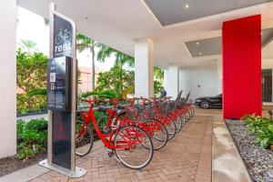 een rij rode fietsen geparkeerd op een parkeerplaats bij Modern one bed at Beach Walk Miami 15th in Hollywood