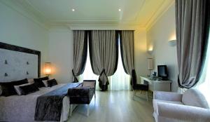 a bedroom with a bed and a couch and a chair at Albergo Palazzo Decumani in Naples