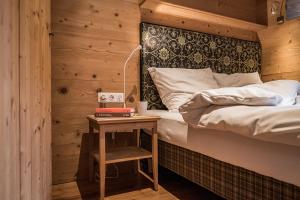 een slaapkamer met een bed en een tafel met een nachtkastje bij Vital Chalet Edelweiss in Schröcken