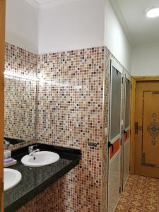 a bathroom with two sinks and a tiled wall at Maison d'Hôtes Casa Azla in Azla