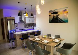 a dining room with a table and chairs and a kitchen at New Luxury 2 Bedroom Apartment with Pool - close to Flic-en-Flac Beach in Flic-en-Flac