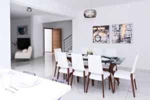 a dining room with a table and white chairs at Villa Sunday in Ayia Napa