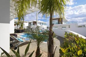 a house with a swimming pool and palm trees at Villa Sunday in Ayia Napa