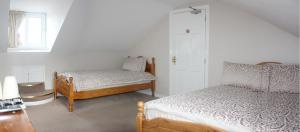1 dormitorio con 2 camas y ventana en Lismore House, en Newry