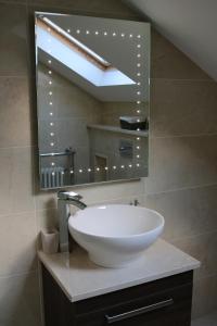 a bathroom with a white sink and a mirror at Lismore House in Newry