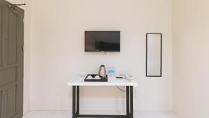 mesa blanca con espejo y TV en la pared en UrbanView at Lacson Street Bacolod City by RedDoorz, en Bacolod