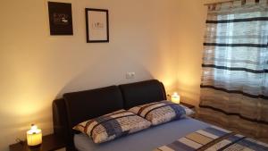 a bed with two lit candles on top of it at Apartments by the sea Cove Saplunara, Mljet - 12849 in Maranovići