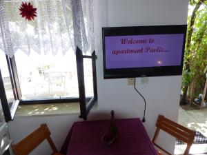 a flat screen tv in a room with a table and chairs at Apartments by the sea Cove Saplunara, Mljet - 12849 in Maranovići