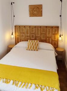 een slaapkamer met een bed met een gele deken erop bij Munigua House in Villanueva del Río y Minas