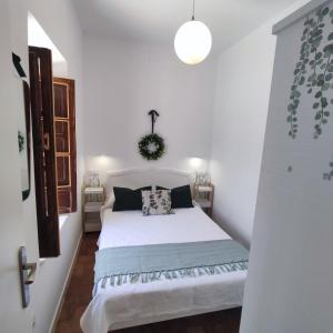 een slaapkamer met een wit bed in een kamer bij Munigua House in Villanueva del Río y Minas
