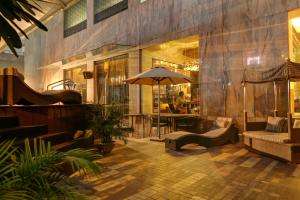 - un hall avec une table et un parasol dans l'établissement Mosaic Hotel, Noida, à Noida