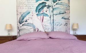 a bed with two purple pillows and a floral wall at Ferienwohnung mit Traumblick und großem Garten in Lindenberg im Allgäu