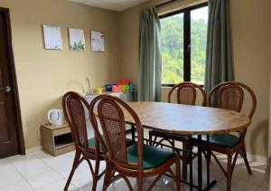 a dining room table with chairs and a kitchen at CORAL BAY APARTMENT 3room (Ocean apartment) in Pangkor