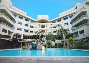 a swimming pool in front of a large building at CORAL BAY APARTMENT 3room (Ocean apartment) in Pangkor