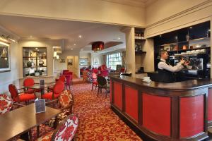 a man taking a picture of a bar in a restaurant at Reigate Manor Hotel in Reigate