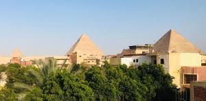 カイロにあるStudio Farida Pyramids Viewの木々の集まる都市のピラミッドの眺め