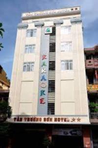 a large white building with a sign on it at Tan Truong Son Hotel in Dong Hoi