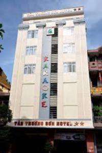 ein großes weißes Gebäude mit einem Schild drauf in der Unterkunft Tan Truong Son Hotel in Dong Hoi