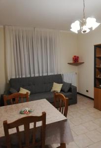 ein Wohnzimmer mit einem Sofa und einem Tisch in der Unterkunft Ginger's House MALPENSA in Cardano al Campo