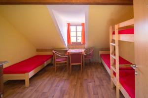 Zimmer mit Etagenbetten sowie einem Tisch und Stühlen in der Unterkunft Ubytovna Pod Hrází in Vyšší Brod