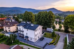 an aerial view of a white house with mountains in the background at Nad Stawem in Ustroń