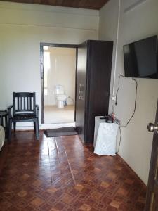 ein Wohnzimmer mit einer Tür, die zu einem Zimmer mit einem Stuhl führt in der Unterkunft Abode Me Me Ai Haven in Cherrapunji
