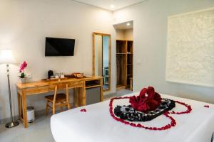 a room with a bed with a desk and a table at Ari Cottages Ubud in Ubud