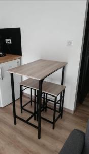 a wooden table with a bench sitting next to a counter at STUDIO A 2 MN DE L A75 in Usclas-lʼHérault