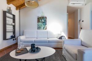 Apartment Tamara Suite - Menaggio في ميناجيو: غرفة معيشة مع أريكة بيضاء وطاولة