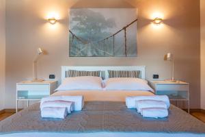 a bedroom with a large bed with a bridge painting on the wall at Apartment Tamara Suite - Menaggio in Menaggio