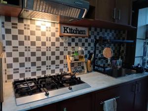 a kitchen with a stove and a sink at Emmir Homestay in Cilacap