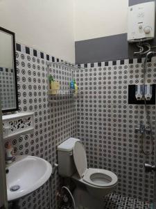 a bathroom with a toilet and a sink at Emmir Homestay in Cilacap