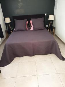 - un lit avec une couette violette et 2 lampes dans l'établissement Casa Petra, à Corte