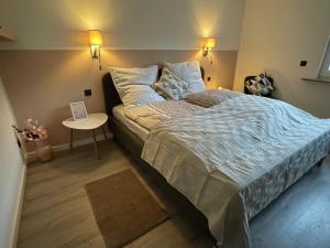 a bedroom with a large bed and a table at Neu! Wellnesshome Fontaneweg Sauna, Terasse, Garten Erstbezug Juli 2022 in Espelkamp