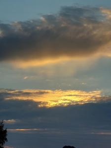 a cloudy sky with the sun setting in the distance at Ferienwohnung Finja - a70682 in Dreschvitz