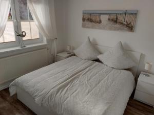 a bedroom with a bed with white sheets and two windows at Ferienwohnung Finja - a70682 in Dreschvitz