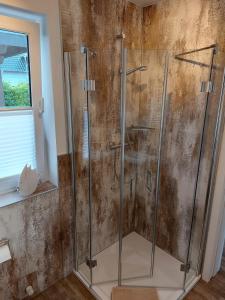 y baño con ducha y puertas de cristal. en Ferienwohnung Finja - a70682, en Dreschvitz