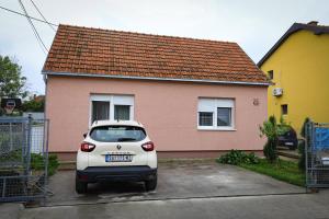 a white car parked in front of a house at Apartman Biljana in Šabac