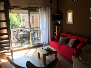 a living room with a red couch and a table at Coup de coeur - Centre station, Proche pistes de ski in Les Deux Alpes