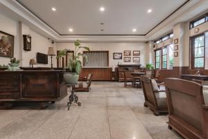 Cette grande chambre comprend des tables, des chaises et un piano. dans l'établissement RedDoorz near Simpang Dago 2, à Bandung